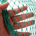 مقرّبة لشبكة حماية خضراء معقودة من خيوط مجدولة سميكة بفتحة 4 سم | Close-up of the heavy knotted green protection net with a 4 cm mesh aperture