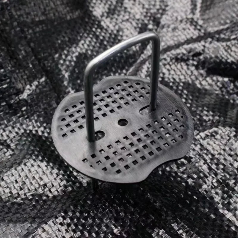 الوتد والقرص وهما يثبّتان غطاء أرضي منسوج لمكافحة الأعشاب | The staple and pad holding down woven weed-control ground fabric