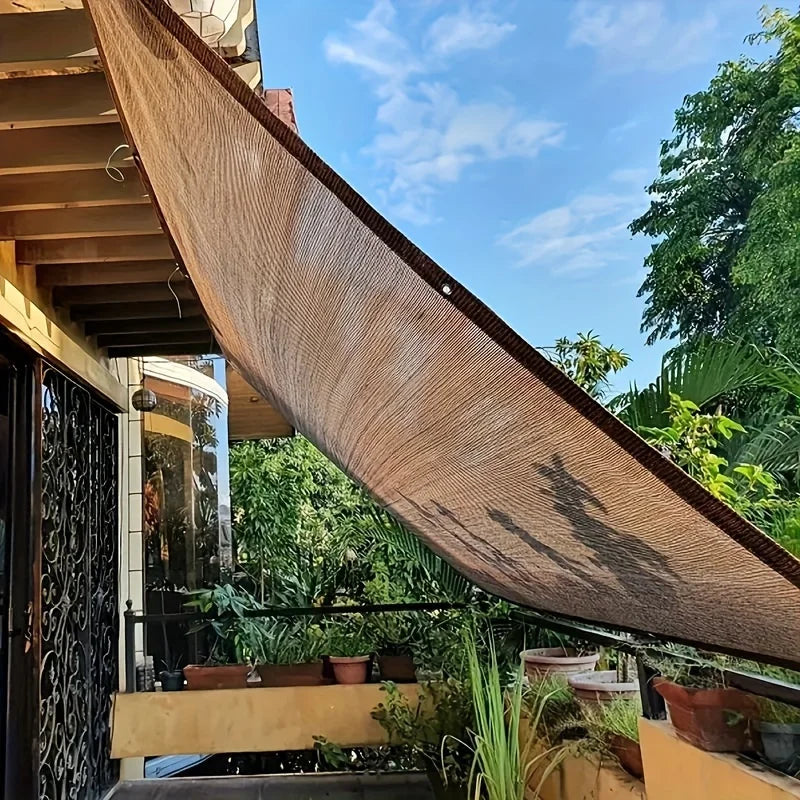 شبك تظليل بنّي ممتد فوق شرفة ومنطقة جلوس خارجية | Brown shade net stretched over a balcony and outdoor seating area