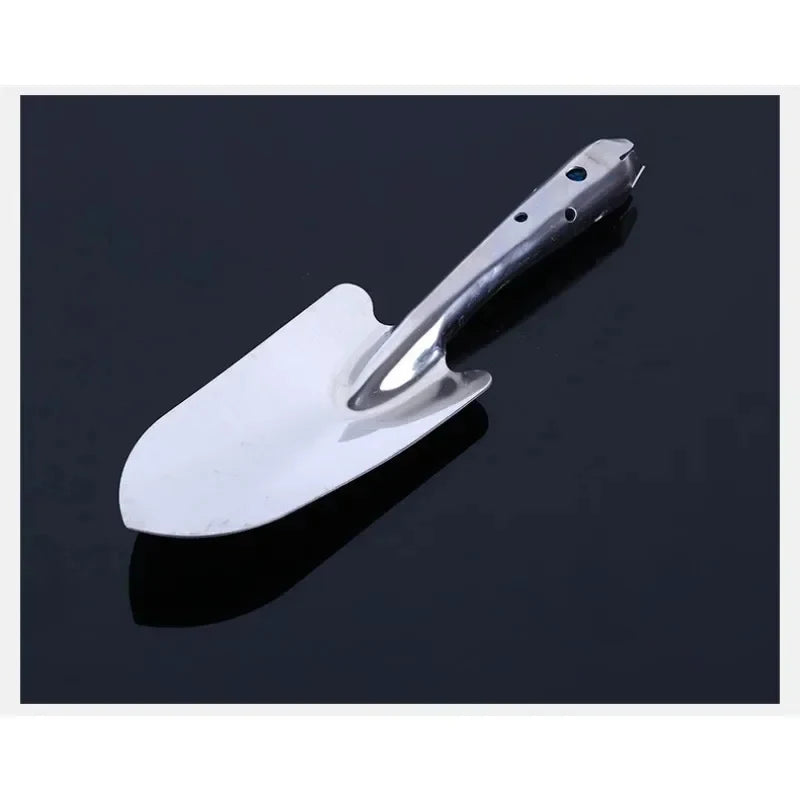 مجرفة زراعة يدوية من الستانلس ستيل على خلفية داكنة | Stainless steel hand trowel on a dark background