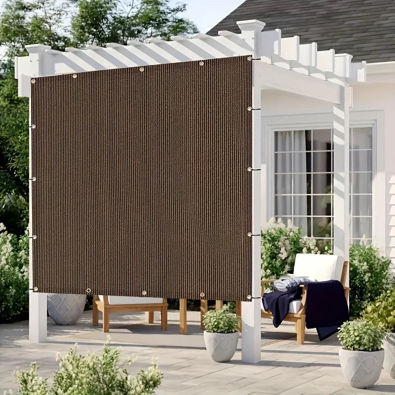 شبك التظليل البنّي مستخدم كساتر جانبي مع حواف مخيطة وحلقات | Brown shade net used as a side screen, showing the taped edge and grommets