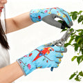 قفازات بستنة زرقاء مطبوعة أثناء استخدام مقص تقليم في الحديقة | Blue printed gardening gloves in use with a pair of pruning shears in the garden